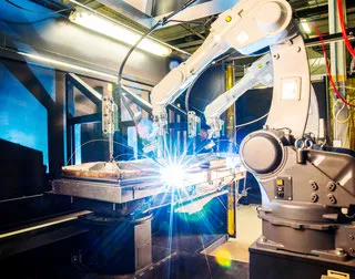 Industrieroboter beim Schweißen, heller Lichtbogen am Werkstück